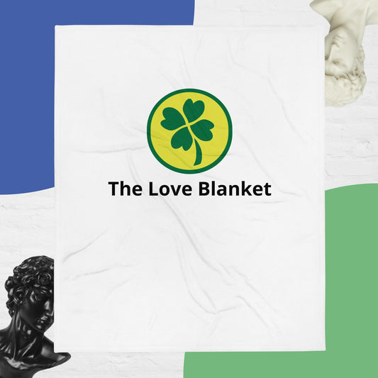 A throw blanket with a green clover design on a white background, with the text 'The Love Blanket' displayed prominently.