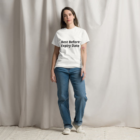 A person standing in a casual pose wearing a white unisex crew neck t-shirt with text on the front, paired with blue jeans and white sneakers.