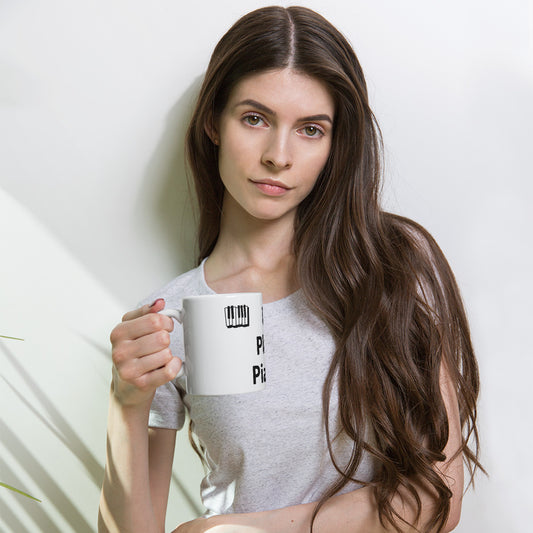 A person holding a white ceramic mug with the text 'I Play Piano' printed on it.
