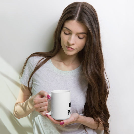 A person holding a white ceramic mug with the text 'I Play Piano' printed on it.
