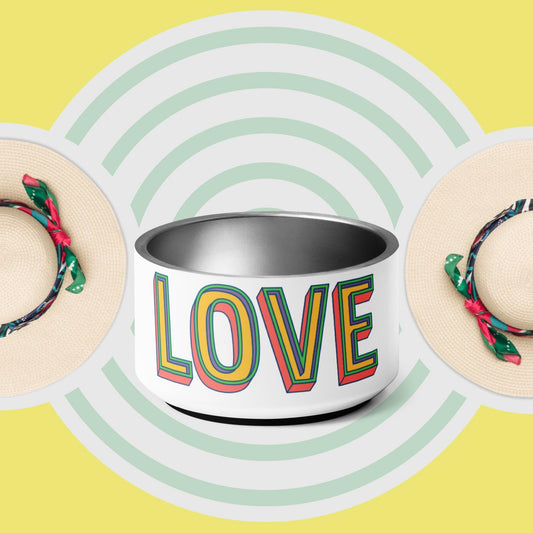 A stainless steel pet bowl with the word 'LOVE' printed on the side, set against a yellow background with a pattern of green concentric circles. The bowl has a double-wall design and anti-slip rubber base.